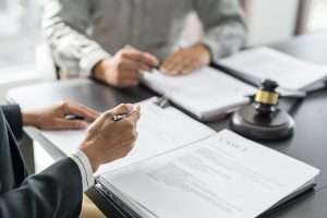 Two people reviewing documents at a table beside a gavel