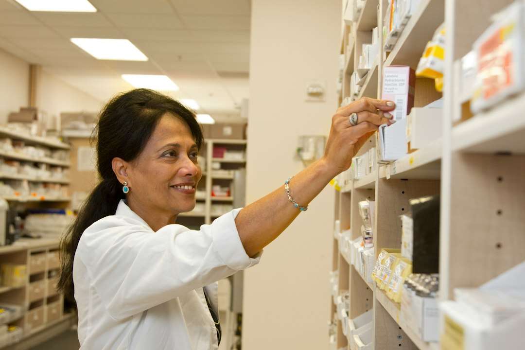 Pharmacist working among medicine shelves in a community pharmacy